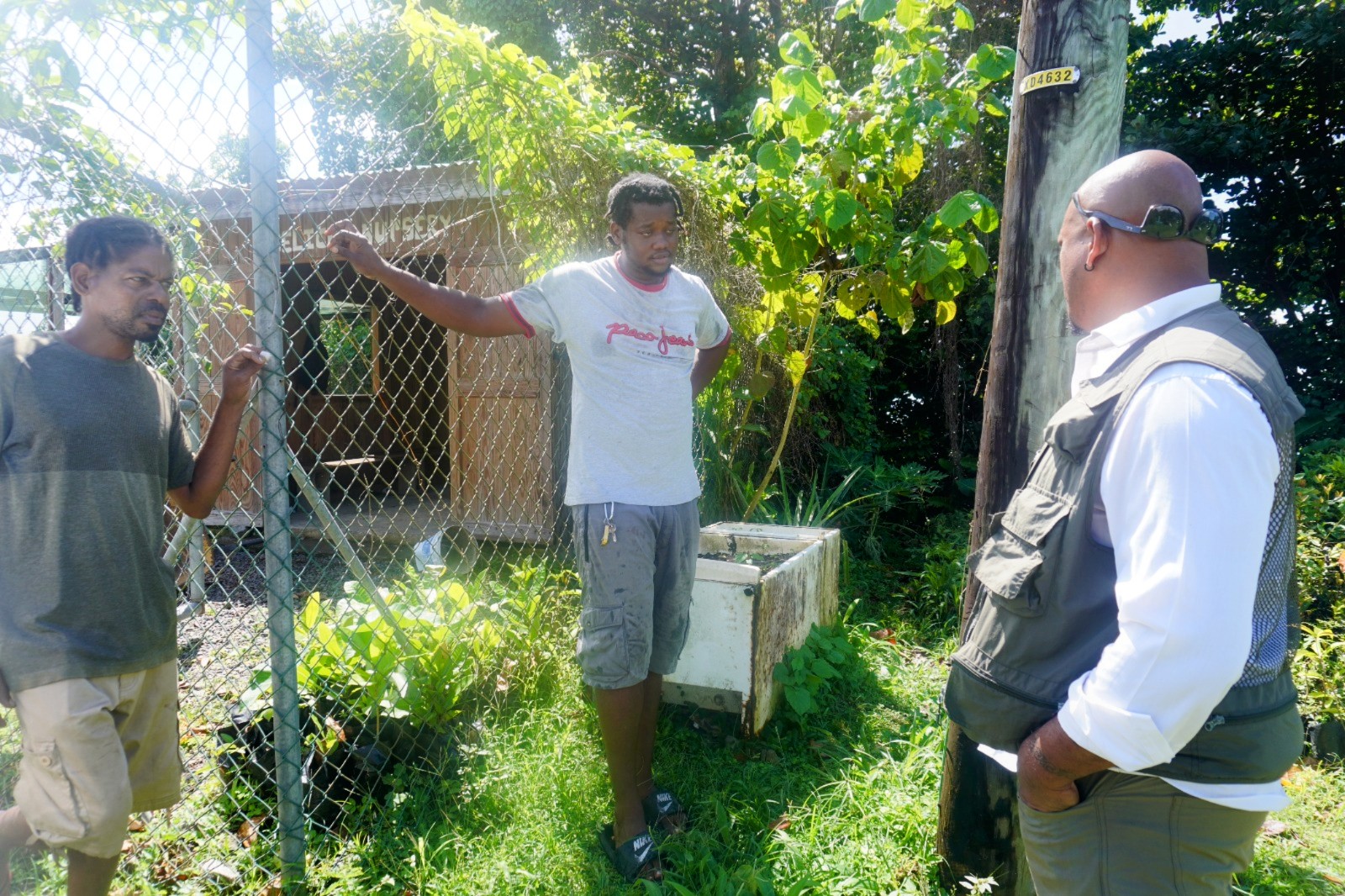 A man from behind, with "Greenpeace" written on his green jacket